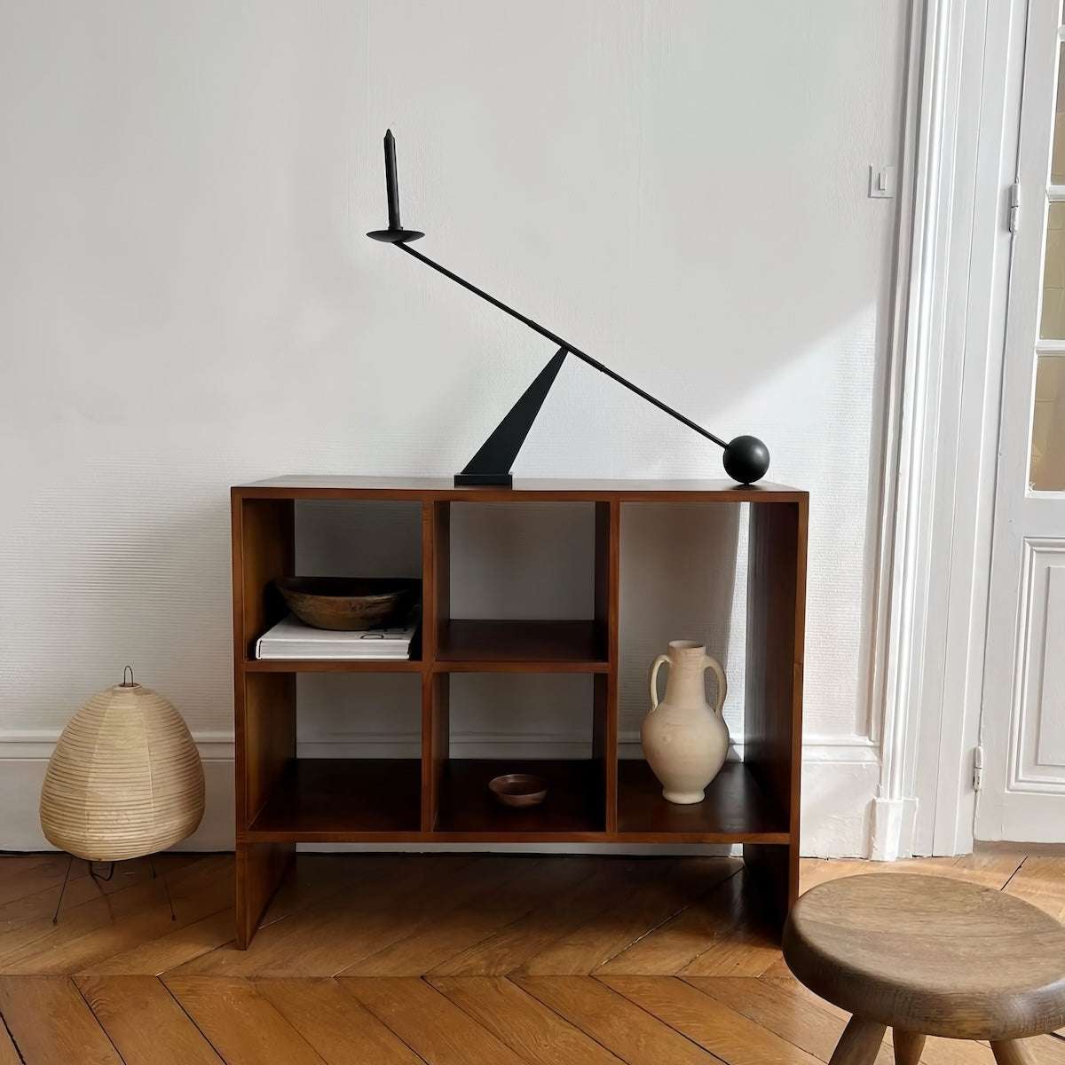 Modern minimalist black candle holder with geometric wabi-sabi design on wooden shelf in elegant home decor setting