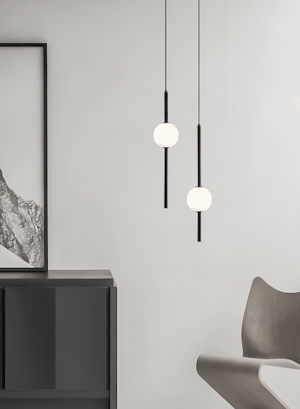 Modern black pendant light with white glass balls hanging in minimalist room interior