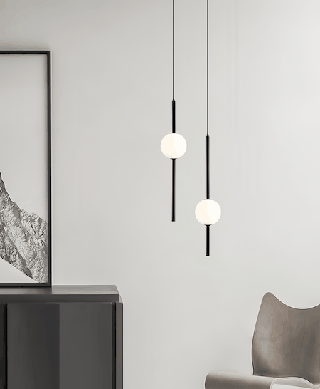 Modern black pendant light with white glass balls hanging in minimalist interior setting