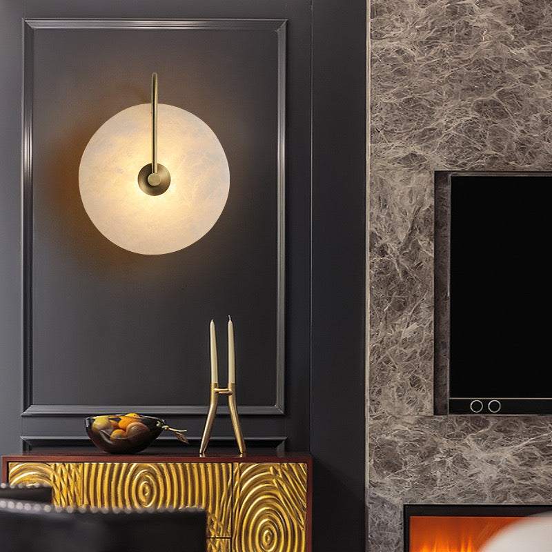 modern marble sconce wall light with gold and black aluminum frame illuminating dark wall