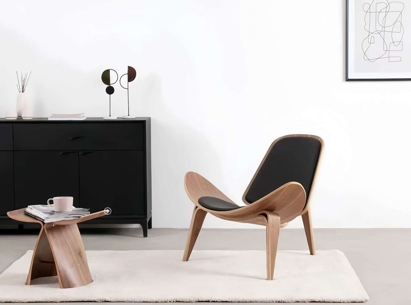 Shell Chair in black and walnut finish with genuine leather upholstery, featuring a sleek silhouette and three-legged design for refined interiors.