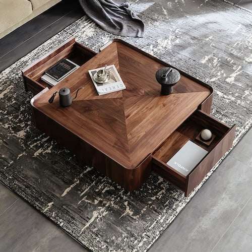 Square walnut coffee table with storage drawers on a modern rug in a living room setting