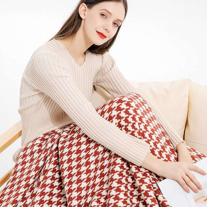 Woman sitting with red and white herringbone knit throw blanket on lap