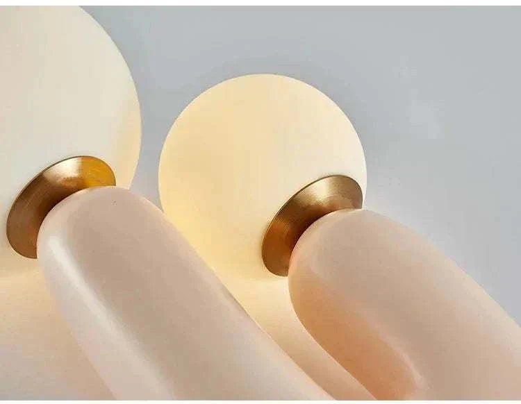 Minimalist tall table lamp with resin base and round glass shade emitting warm ambient light