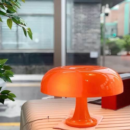 Orange acrylic LED mushroom lamp on a table with a modern background