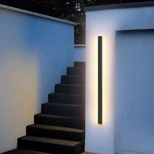 Waterproof IP65 outdoor wall light slim black LED fixture illuminating front door stairway