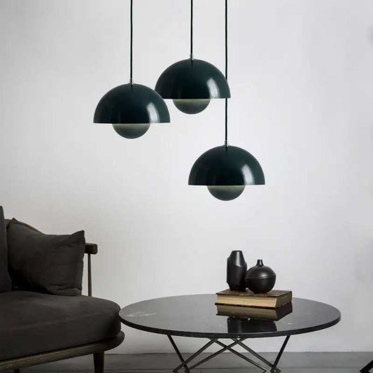 Modern Nordic kitchen island pendant lighting with black mushroom-shaped iron lampshades hanging above a round table in a minimalist room