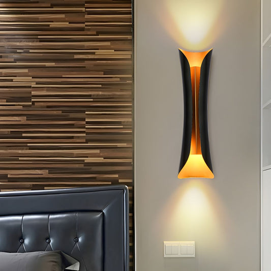 Modern black metallic curl sconce light bulb wall fixture with warm indoor lighting