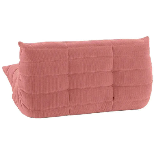 Pink corduroy loveseat sofa with a low, rounded silhouette and distinctive quilted pleats.