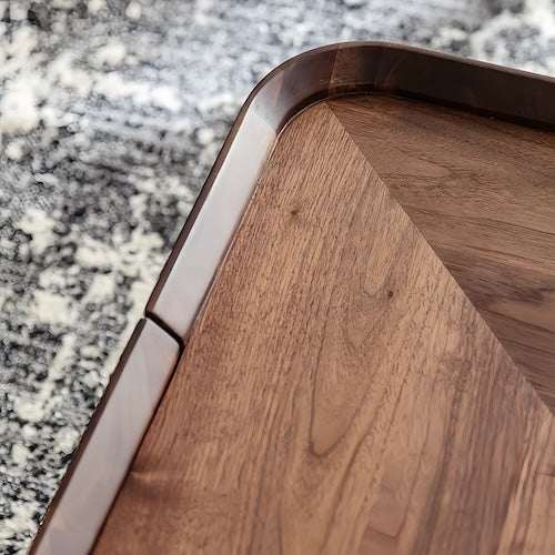 Close-up of walnut coffee table corner with smooth rounded edges and rich wood grain finish