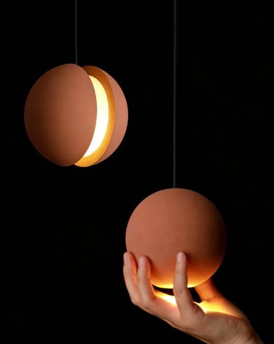 Concrete moon pendant light with industrial fish-shaped stone design and warm LED lighting