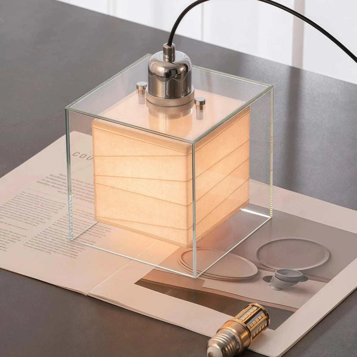 Square rice paper pendant light with chrome frame and adjustable cord hanging in bedroom bedside setting
