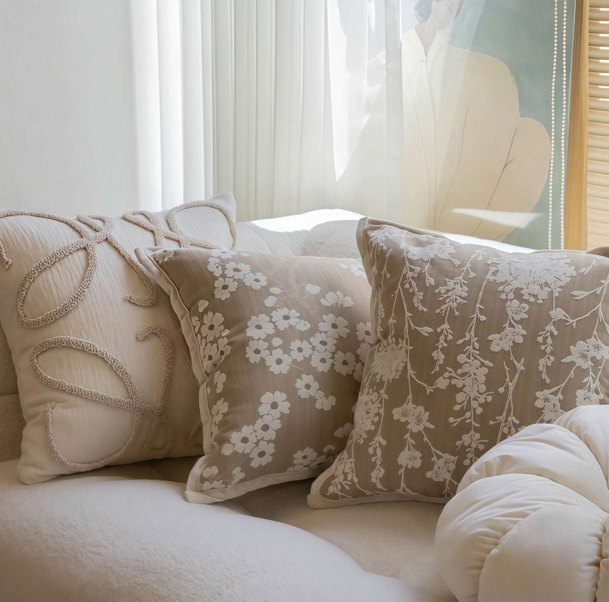 French-Style Embroidered Throw Pillow in taupe fabric with cream floral embroidery and raised looped detailing on a square cover.