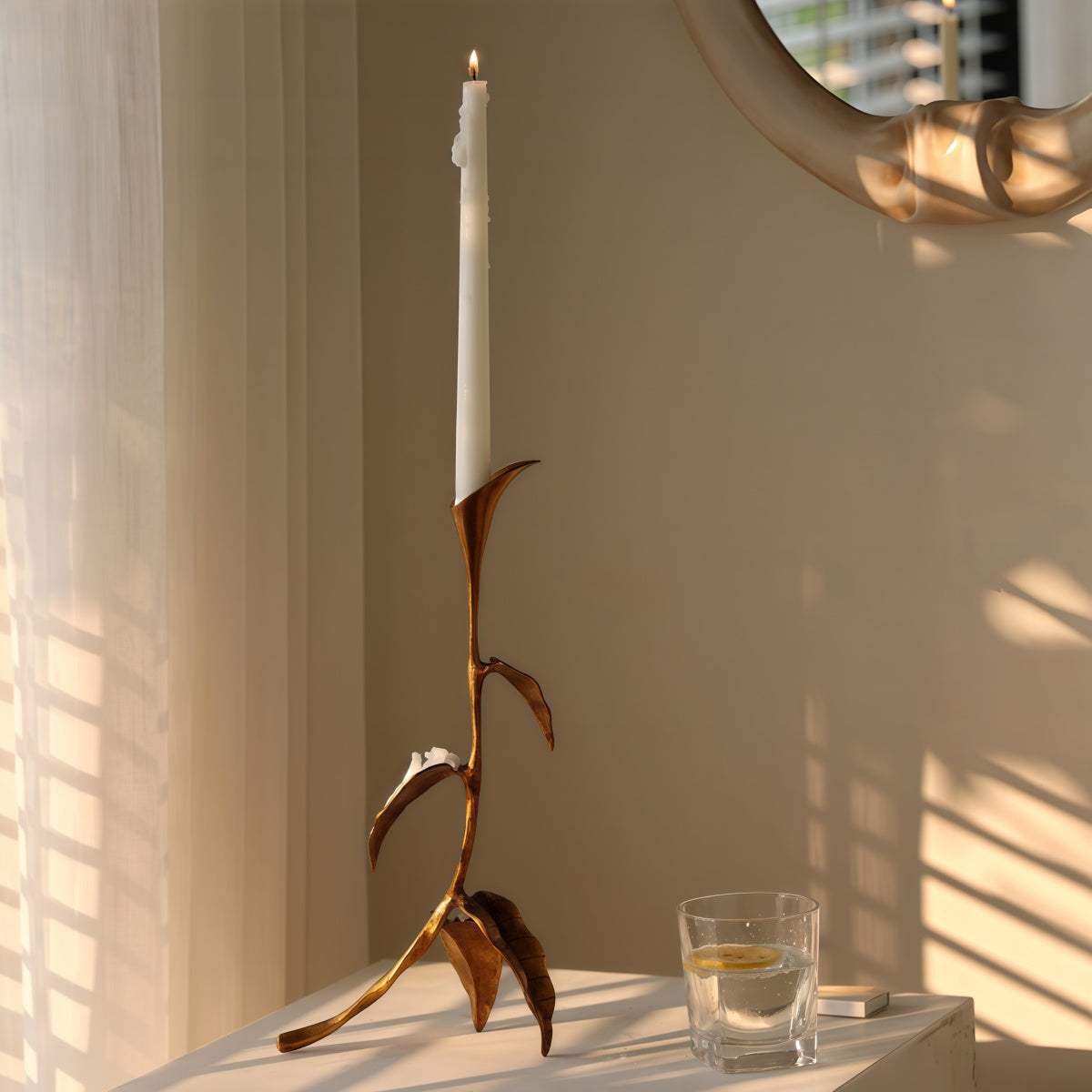 Cast Bronze Calla Lily candle holder with slender floral stem, warm brown metallic finish and tall white taper candle