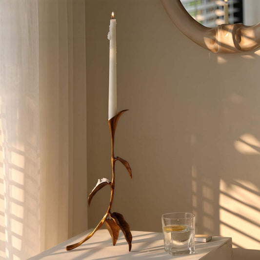 Cast Bronze Calla Lily candle holder with slender floral stem, warm brown metallic finish and tall white taper candle