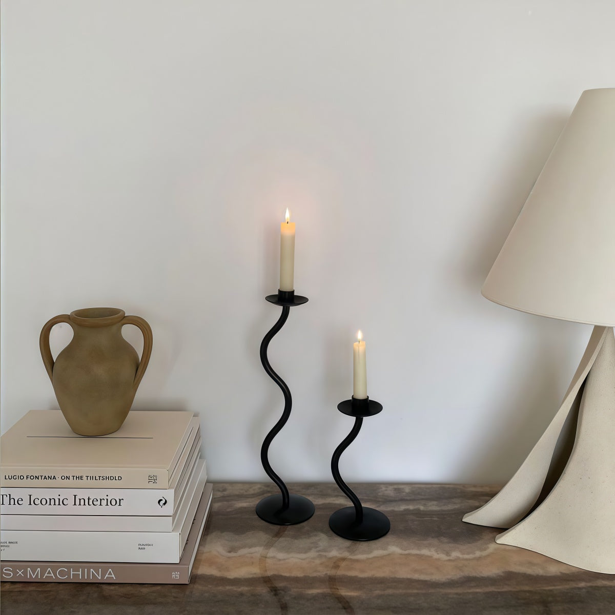 High-End Decorative Wrought Iron Candle Holder in black iron, with twin curved stems and lit taper candles
