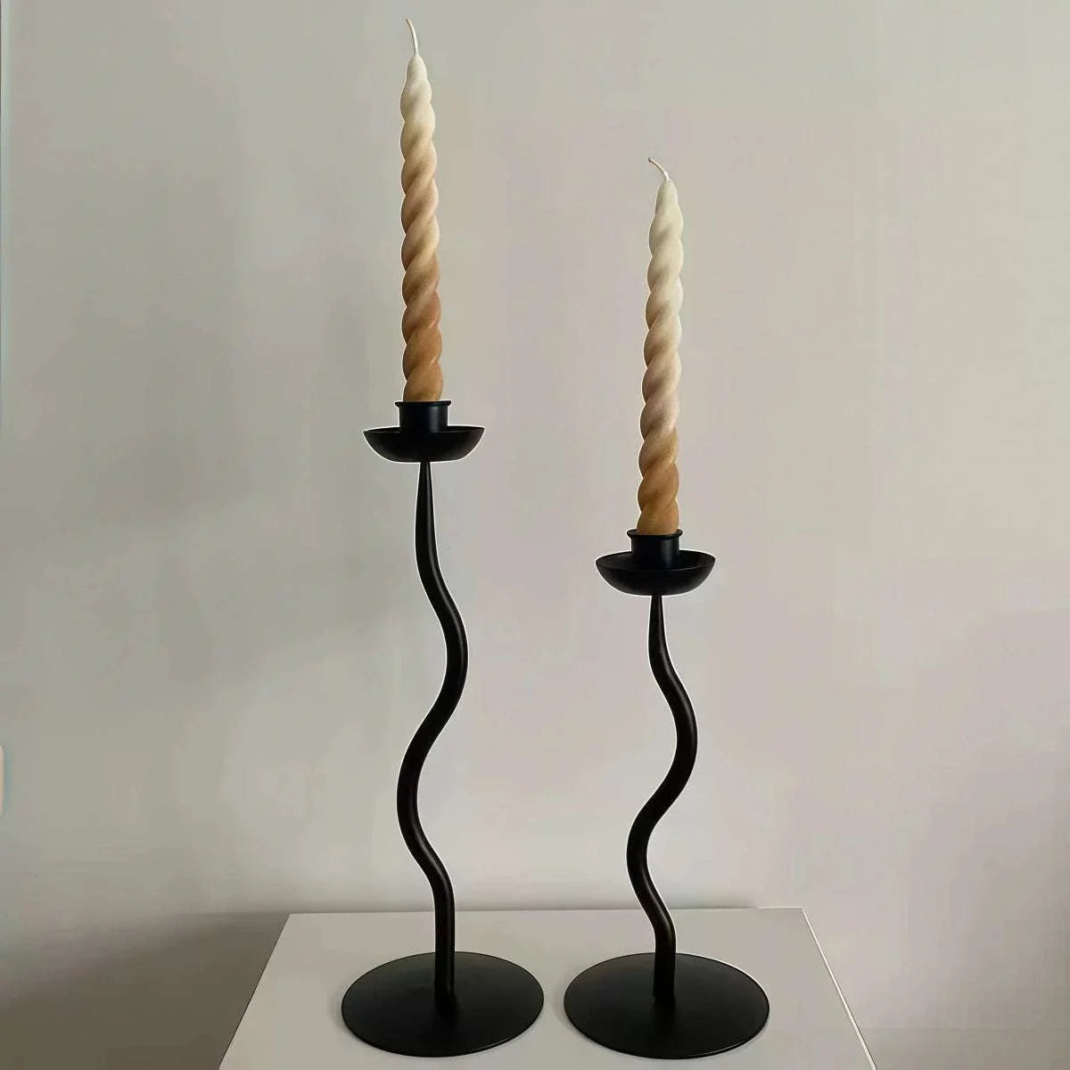 High-End Decorative Wrought Iron Candle Holder, black metal pair with curved stems and twisted beige taper candles