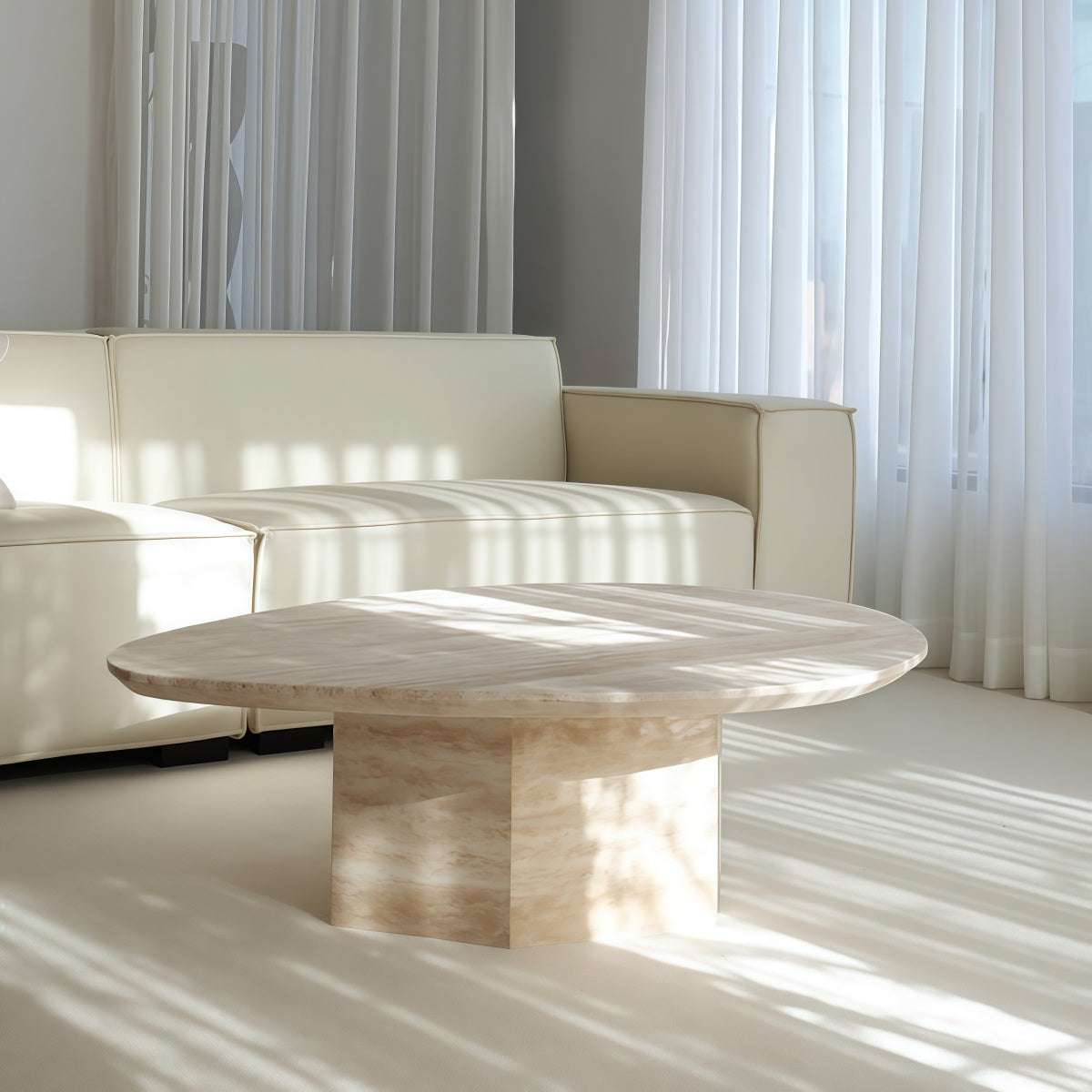 Coffee table in Natural Yellow Travertine with irregular oval top, veined stone surface, and sculptural pedestal base