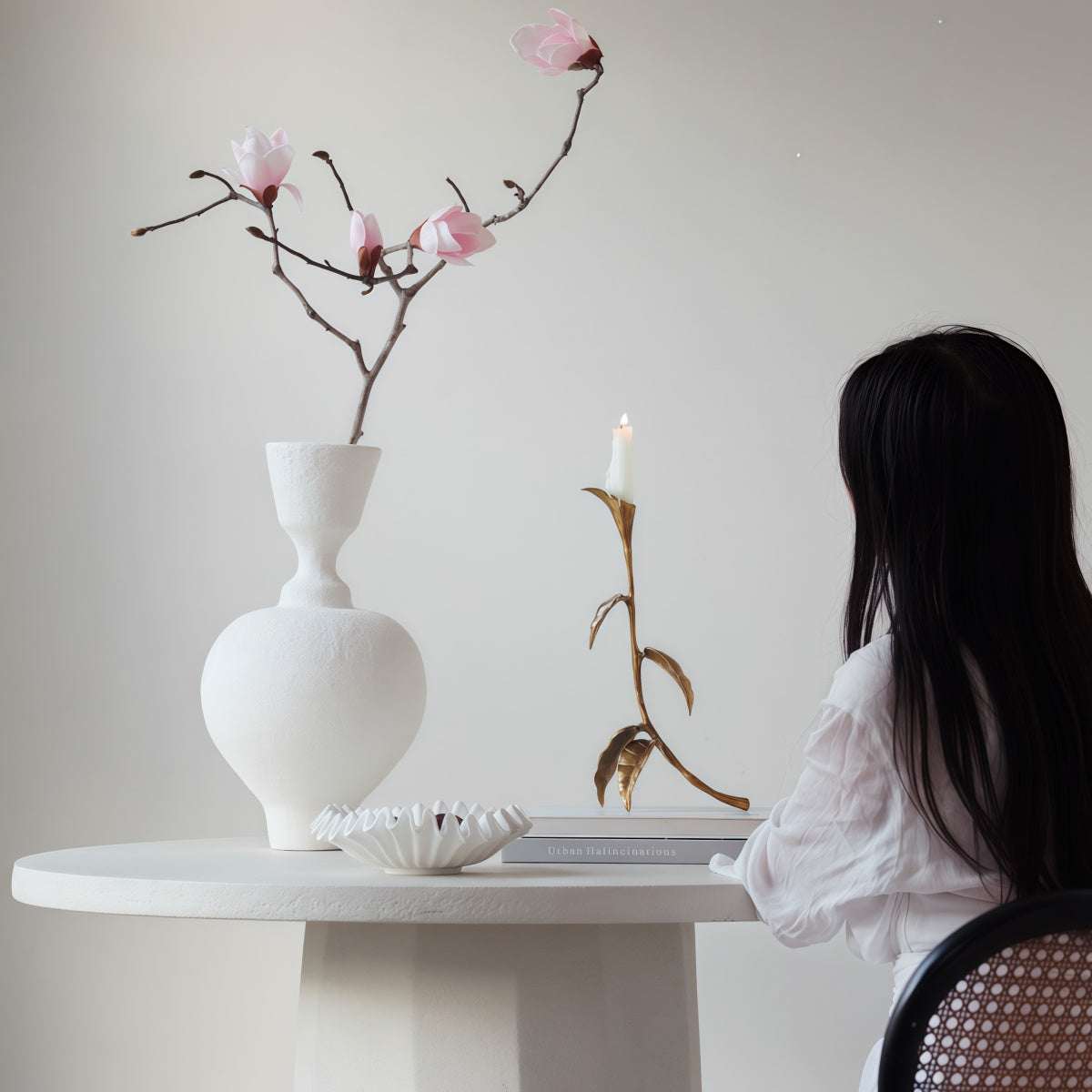 Cast Bronze Calla Lily candle holder with sculptural bronze stem, curved leaves and a lit white candle
