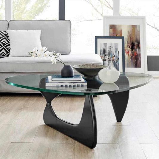 Noguchi Table Replica with clear glass top and black interlocking wood base in modern living room setting