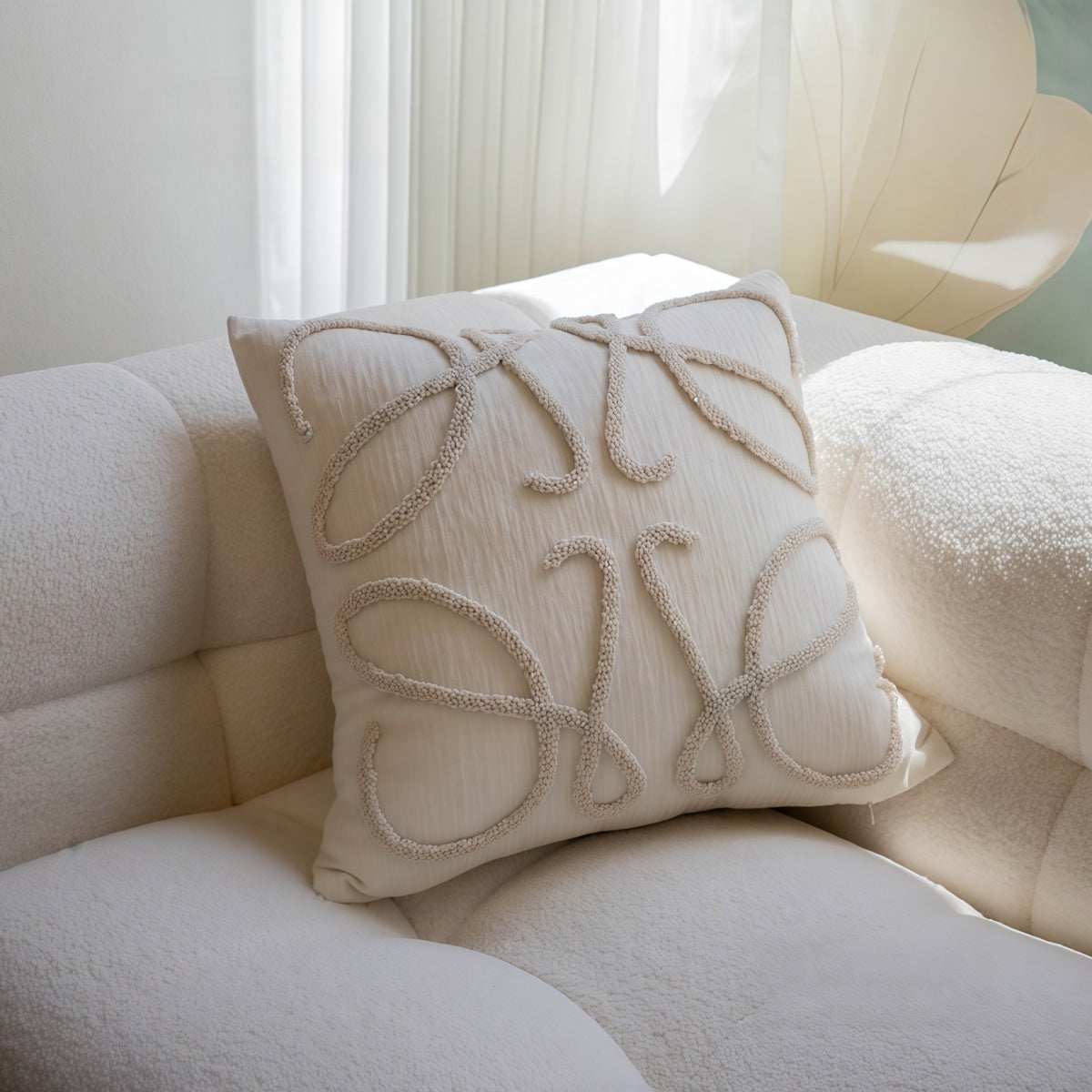 French-Style Embroidered Throw Pillow in ivory textured fabric, featuring raised cream embroidery in an ornate looping pattern.