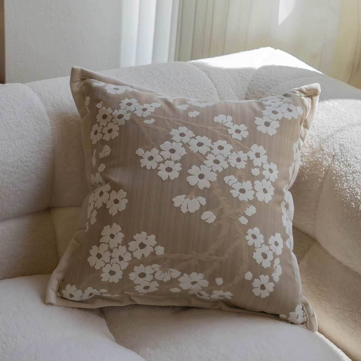 French-Style Embroidered Throw Pillow with a taupe fabric cover, white floral embroidery, and piped edges.