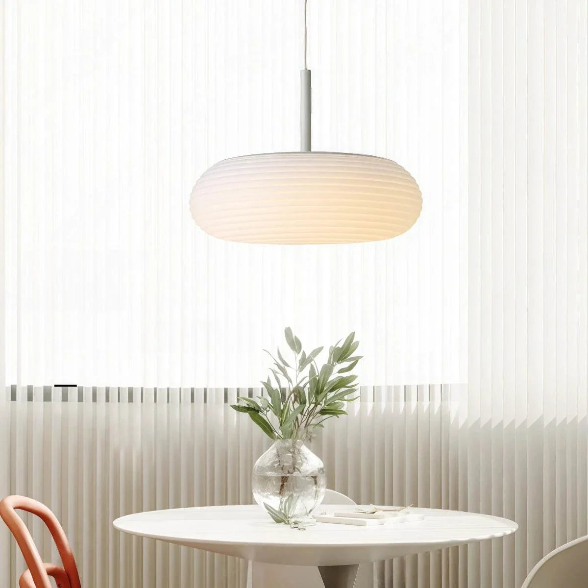 Minimalist Nordic pendant light with oval ribbed PE shade and adjustable cord hanging over dining table