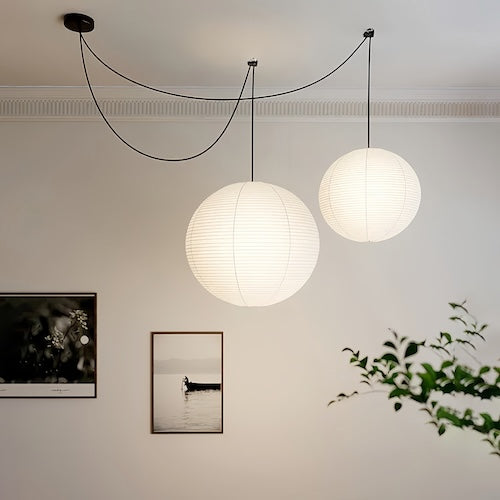 Noguchi Isamu rice paper pendant light illuminating room with bamboo furniture