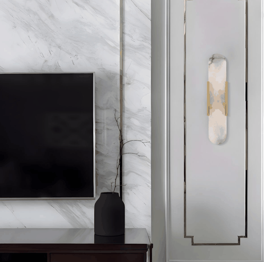 Modern marble wall light with gold and black finishes mounted on elegant wall panel next to TV