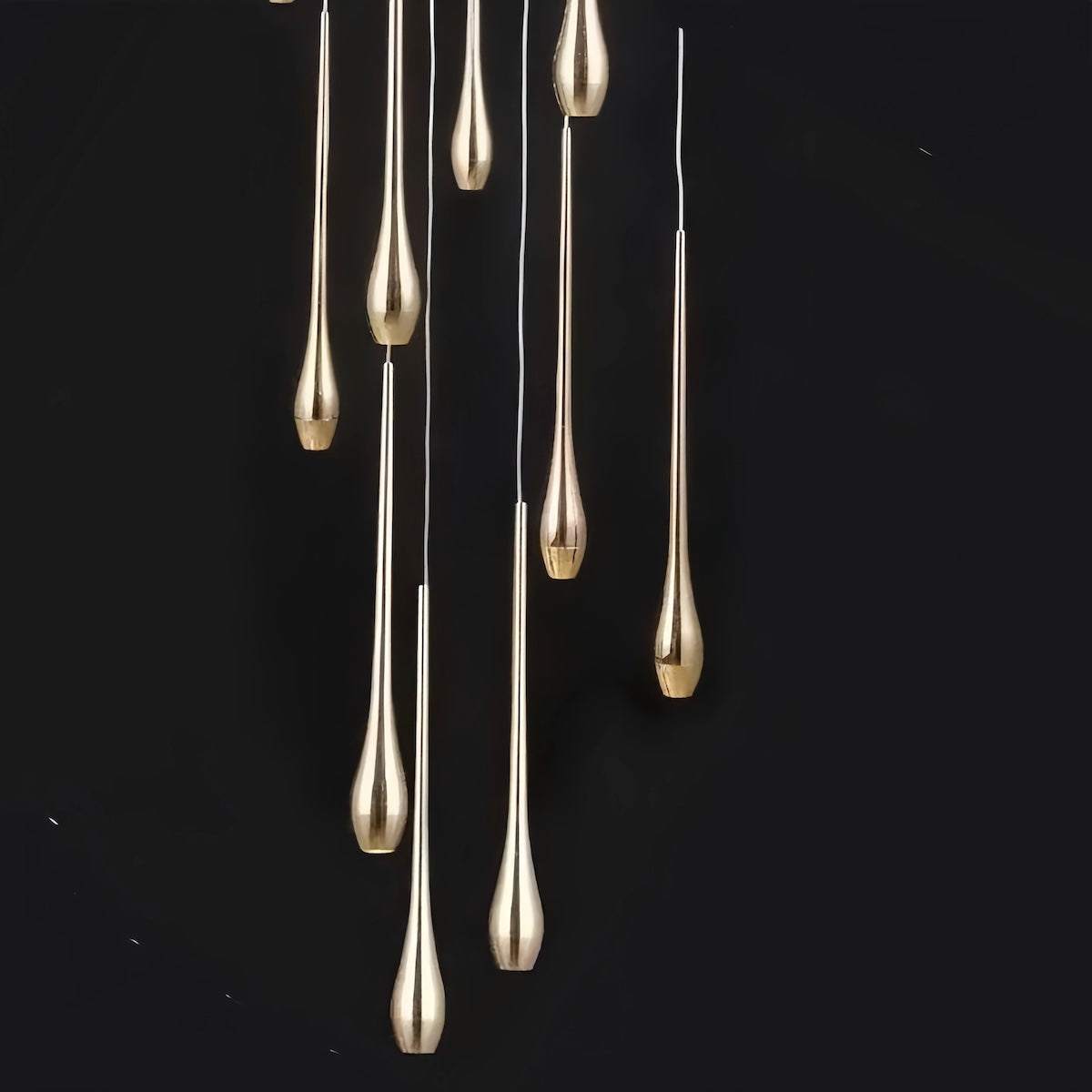 Minimalist LED chandelier with gold teardrop-shaped pendant lights hanging from stainless steel ceiling plate against black background