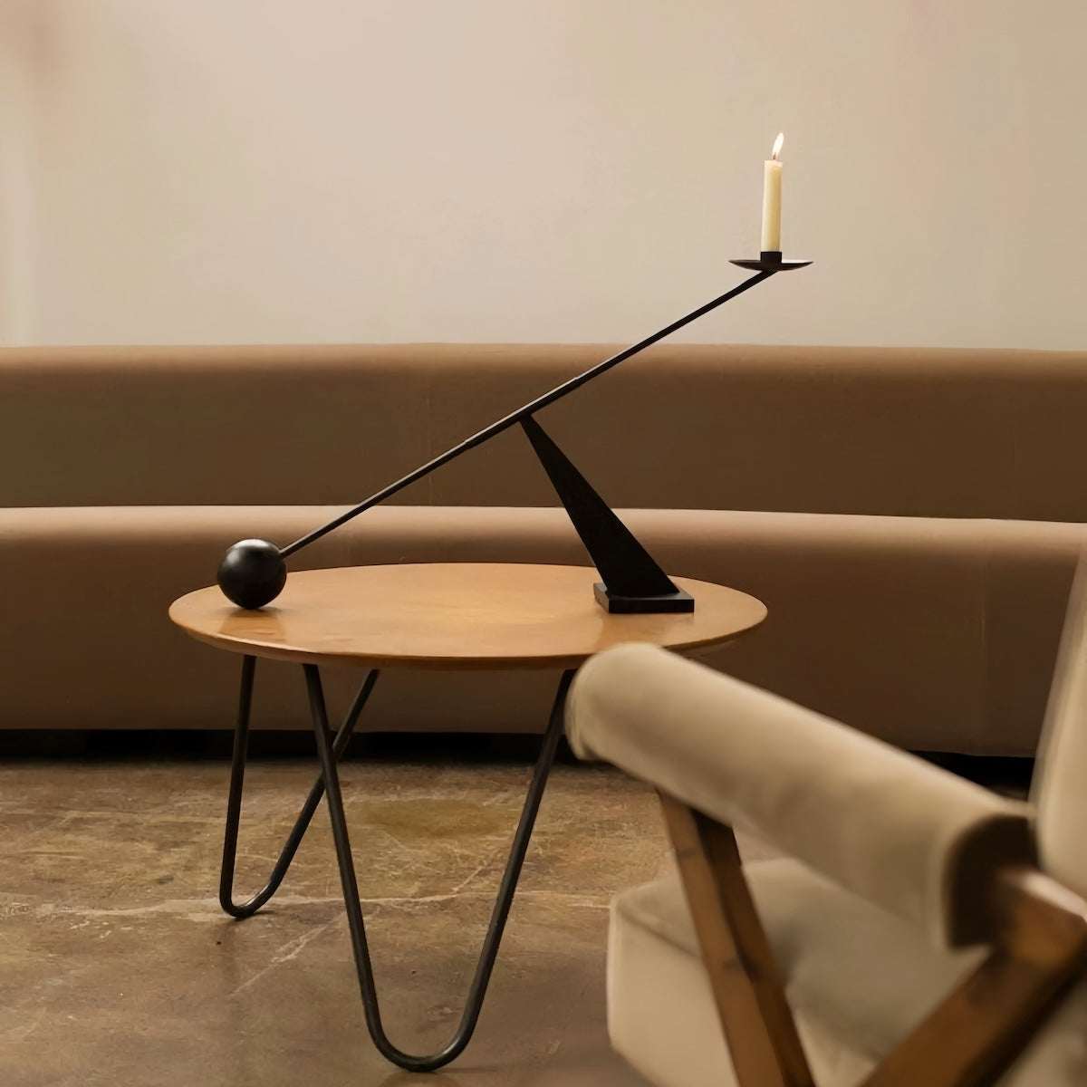 Modern minimalist black candle holder with geometric metal design on wooden table in elegant living room setting