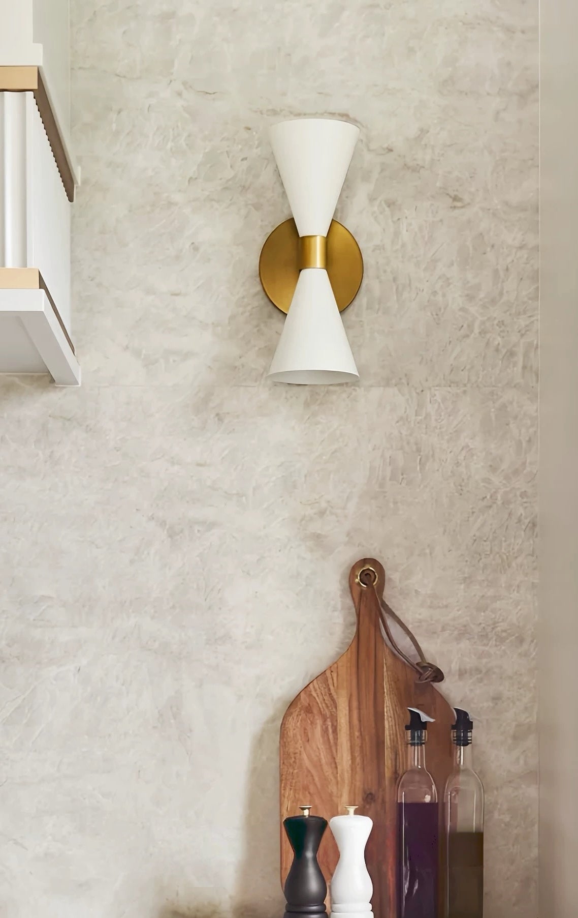 Nordic modern hourglass wall sconce with frosted glass and chrome finish illuminating living room ambiance