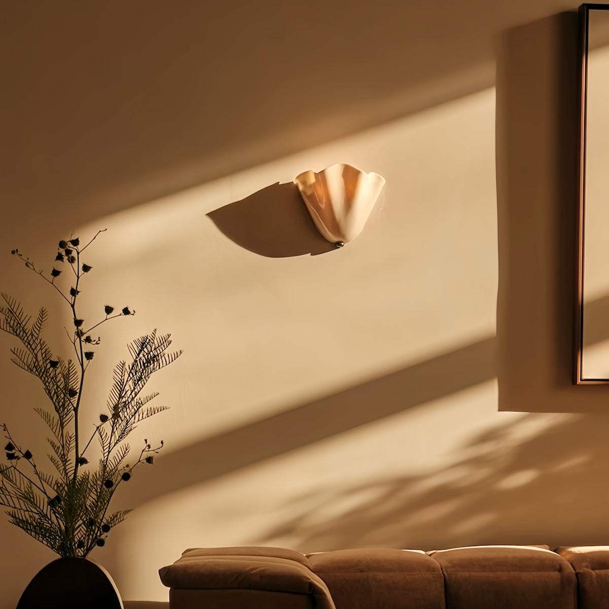 Vintage glass wall lamp with curved shade casting warm light in elegant living room setting