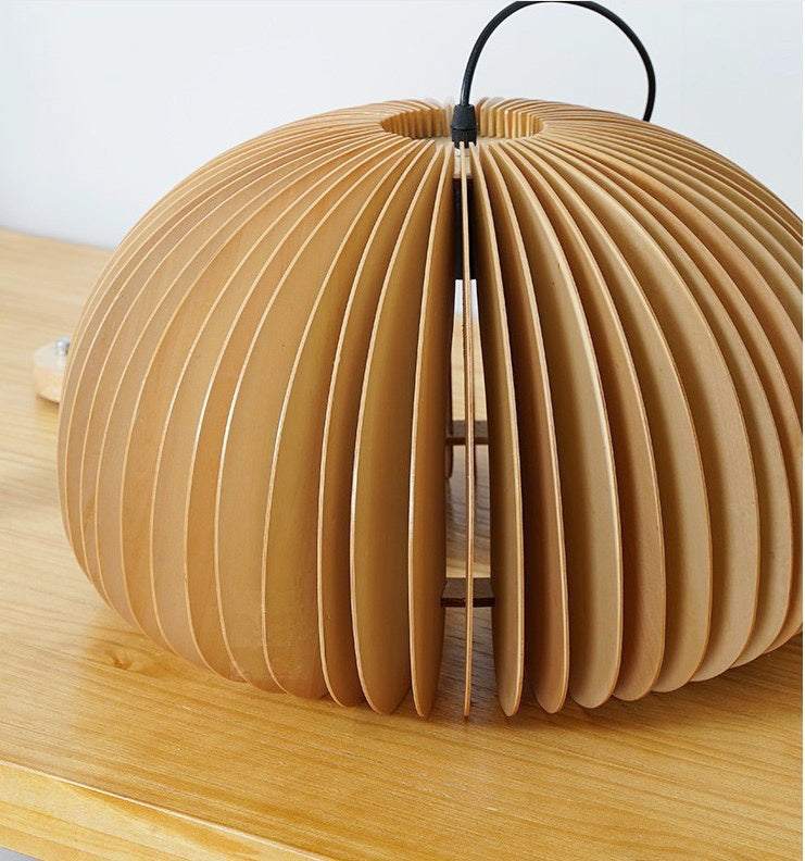 Modern adjustable wood pendant light with hand-knitted basswood blades on wooden surface