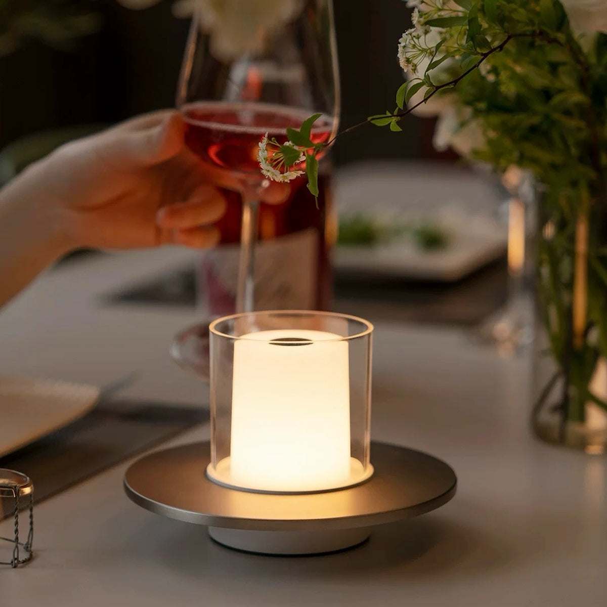 Rechargeable ambience night lamp with warm LED glow on dining table for cozy outdoor setting