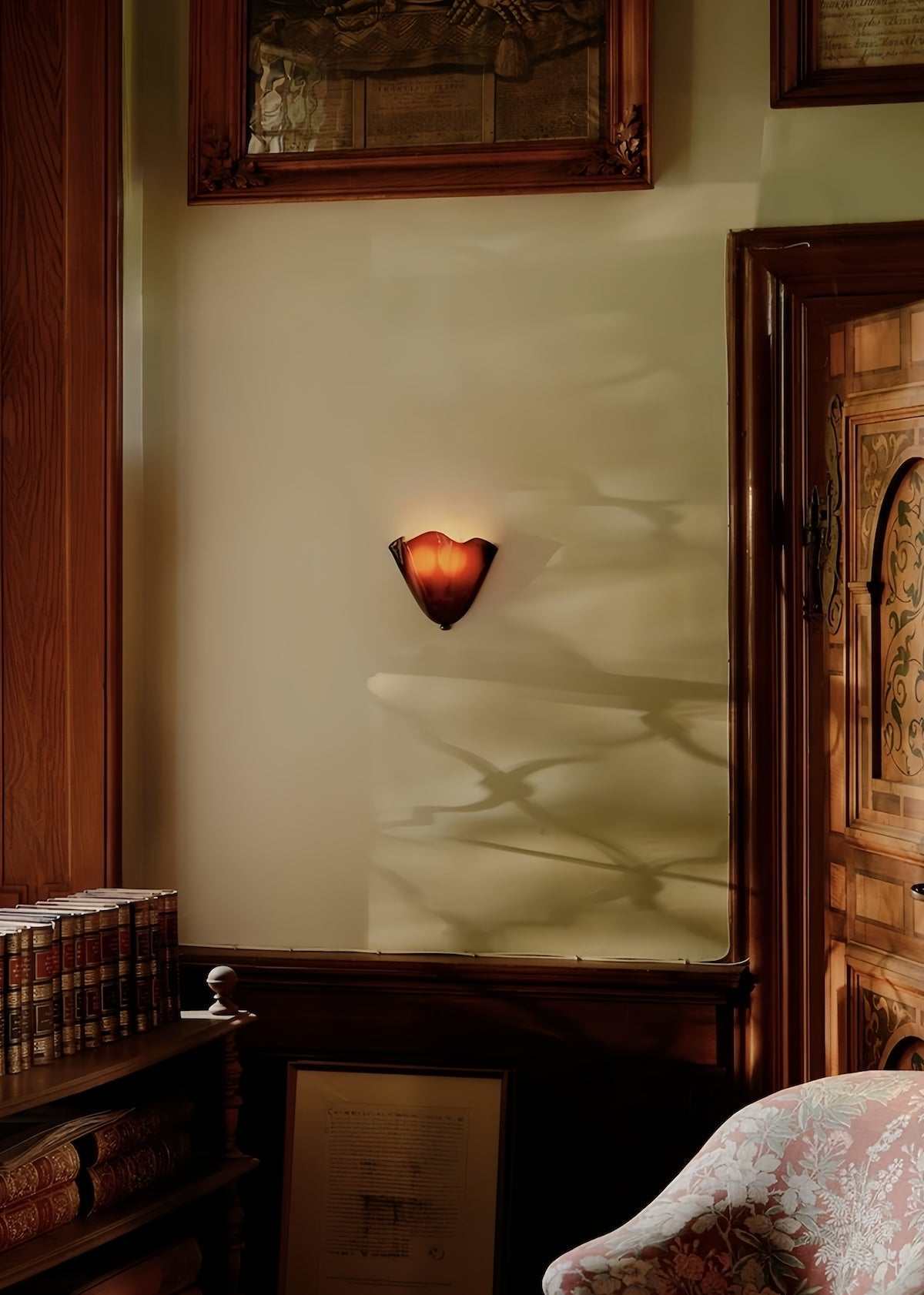 Vintage glass wall lamp with warm light casting soft shadows in classic hallway setting