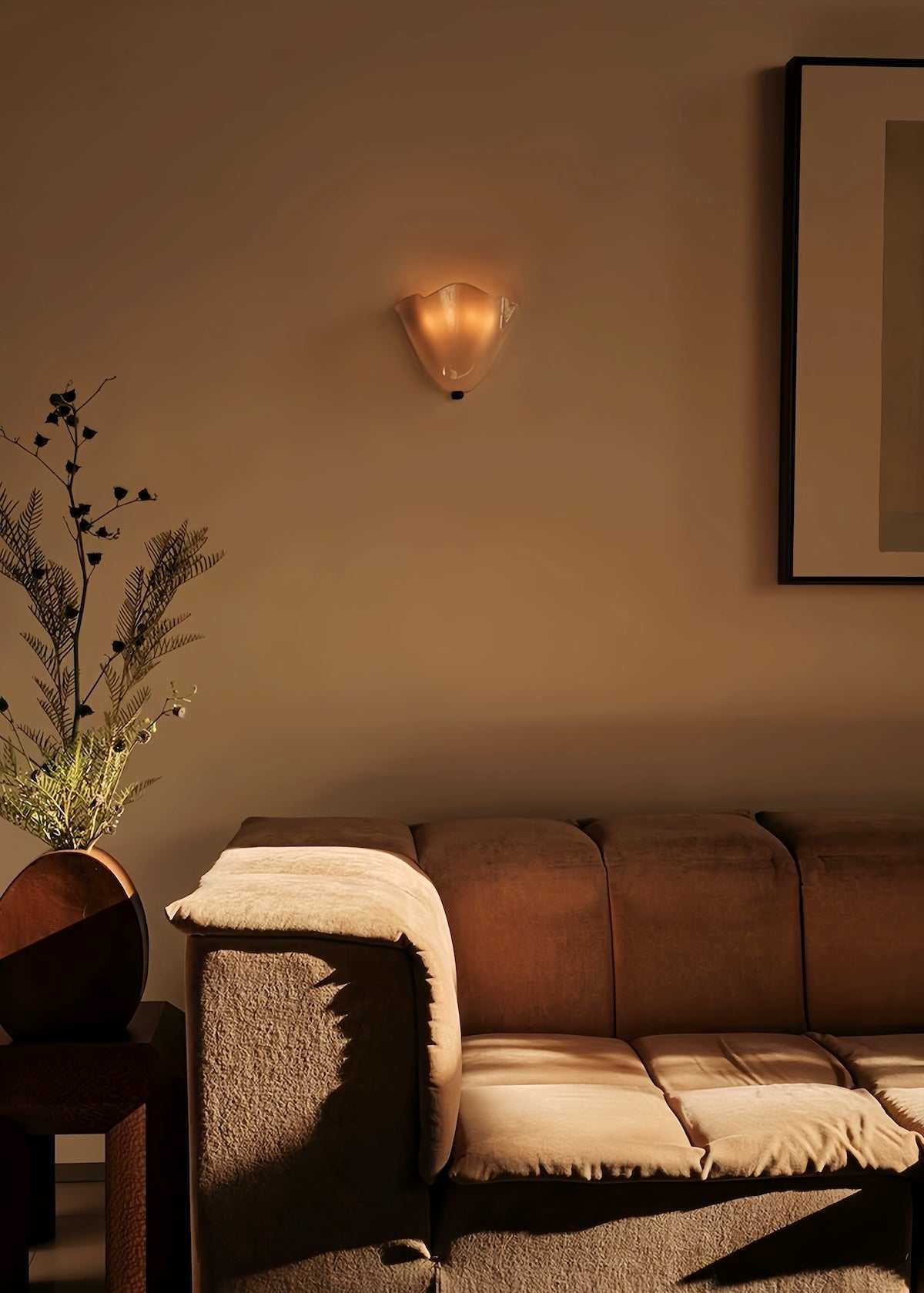 Vintage glass wall lamp with warm LED light above brown sofa in cozy living room