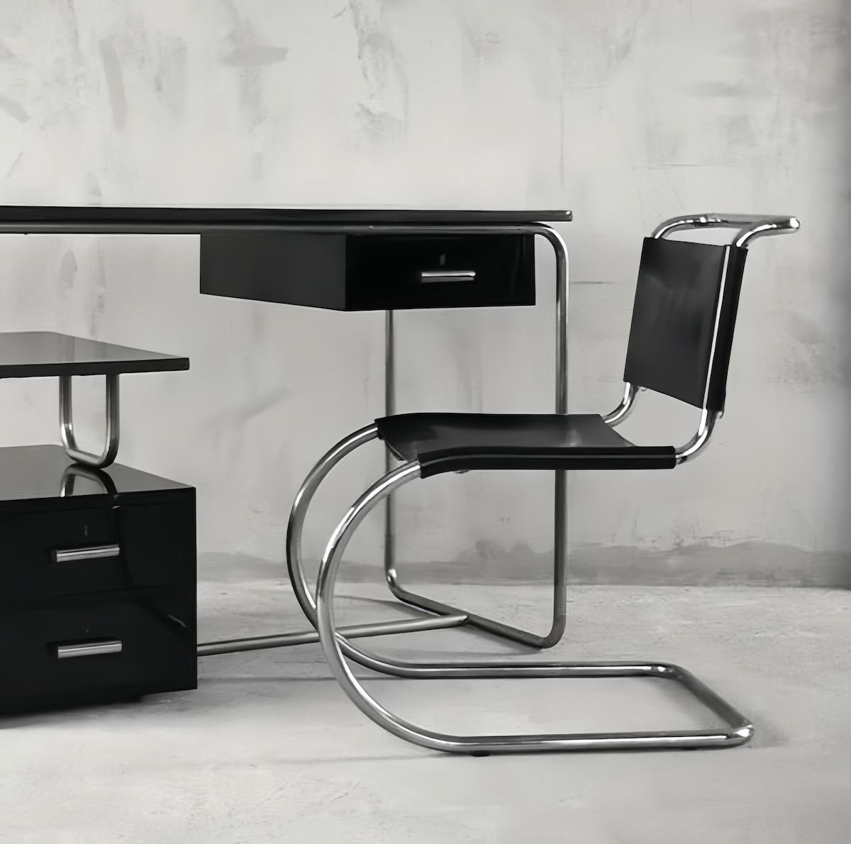 Minimalist stainless steel dining chair with black seat and backrest, modern armless design in a sleek office setting