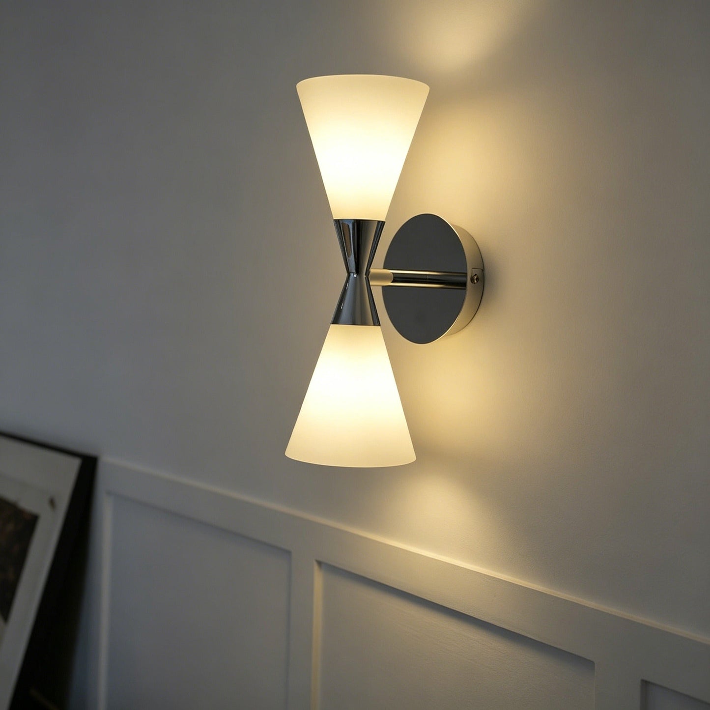 Nordic modern hourglass wall sconce with chrome-plated carbon steel body and glass lampshade illuminating living room ambiance