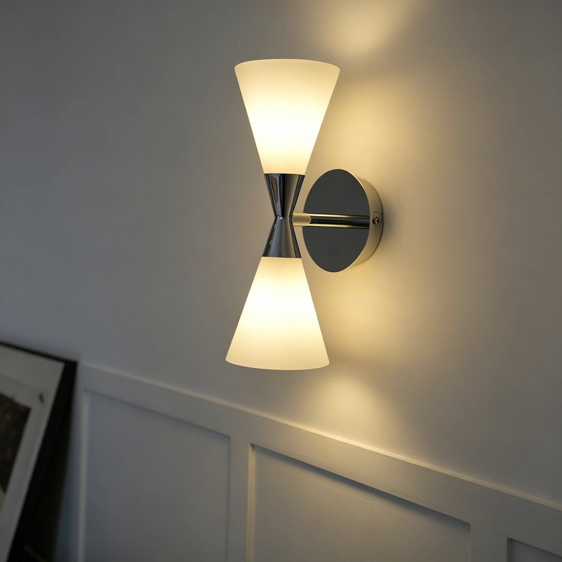 Nordic modern hourglass wall sconce with chrome-plated carbon steel body and glass lampshade illuminating living room ambiance