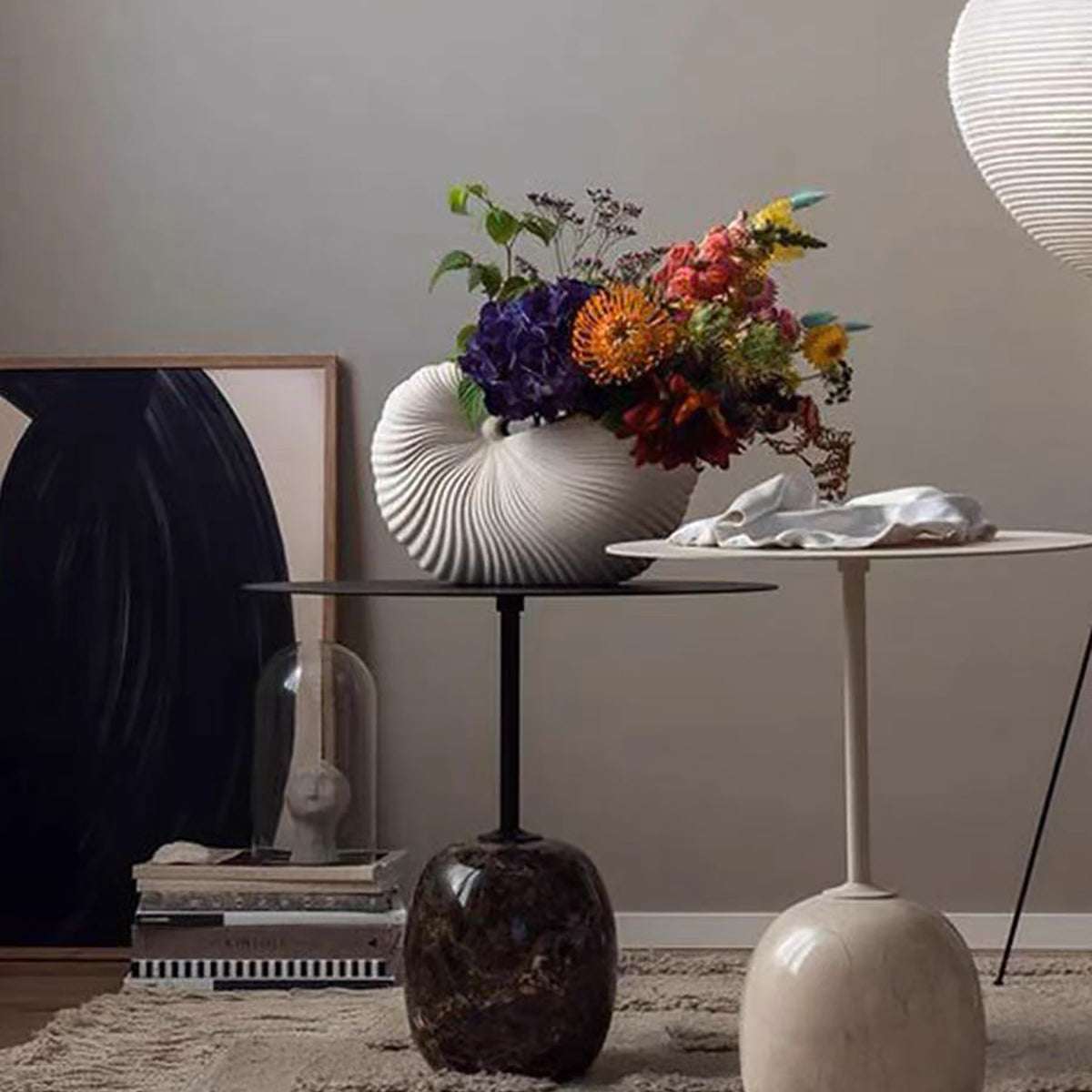Nordic style ceramic seashell vase with matte finish and colorful flowers on modern black table in minimalist room