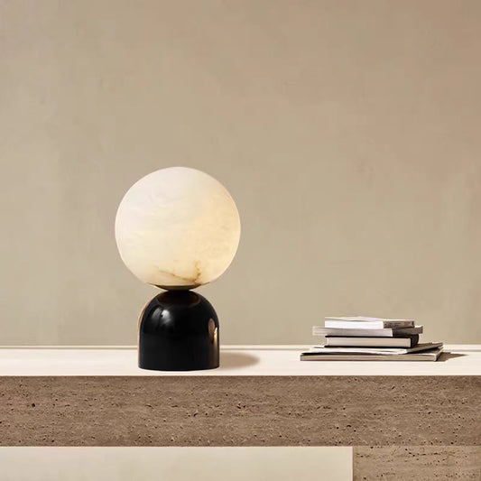 Elegant marble table lamp with Spanish cloud stone globe and black base on modern desk