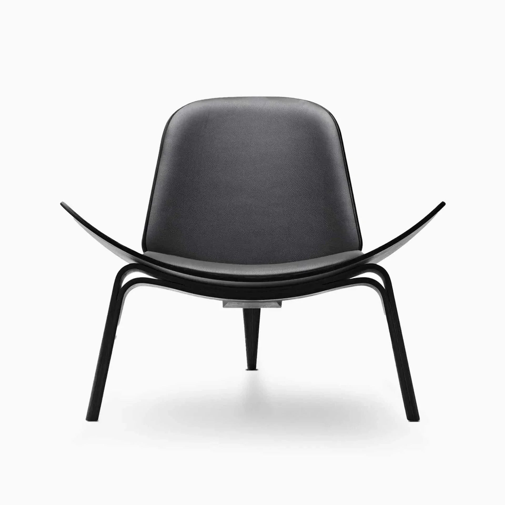 Shell Chair in black leather and walnut finish, featuring sleek Danish mid-century design with ergonomic curved seat and three-legged frame.