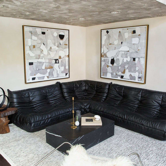 Luxury black leather sectional sofa in modern living room with abstract wall art