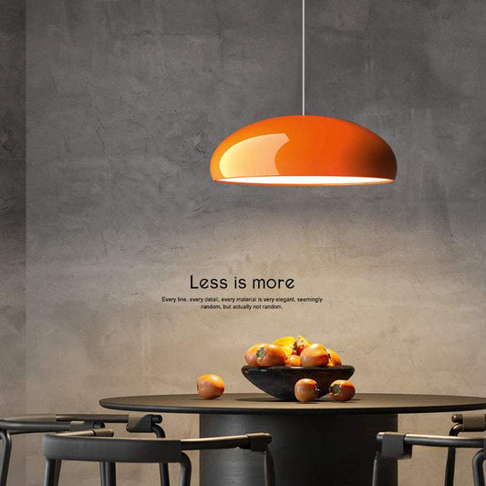 Modern orange pendant lighting with sleek chrome finish hanging above dining table in minimalist room