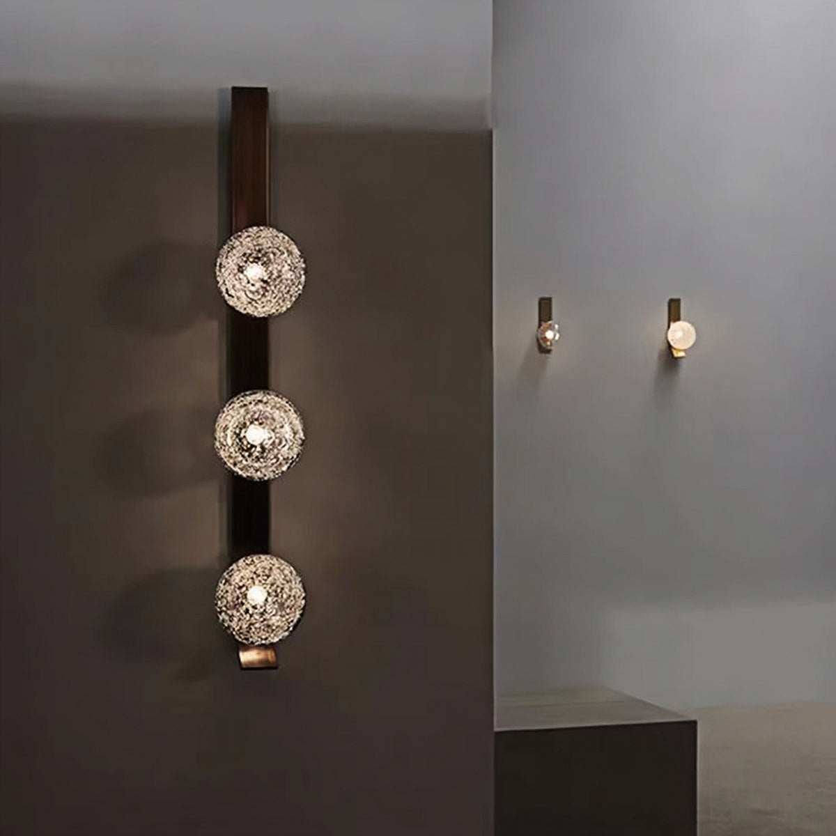 Luxury wall lamp with triple bubble glass lights on iron frame casting warm ambient glow on dark wall
