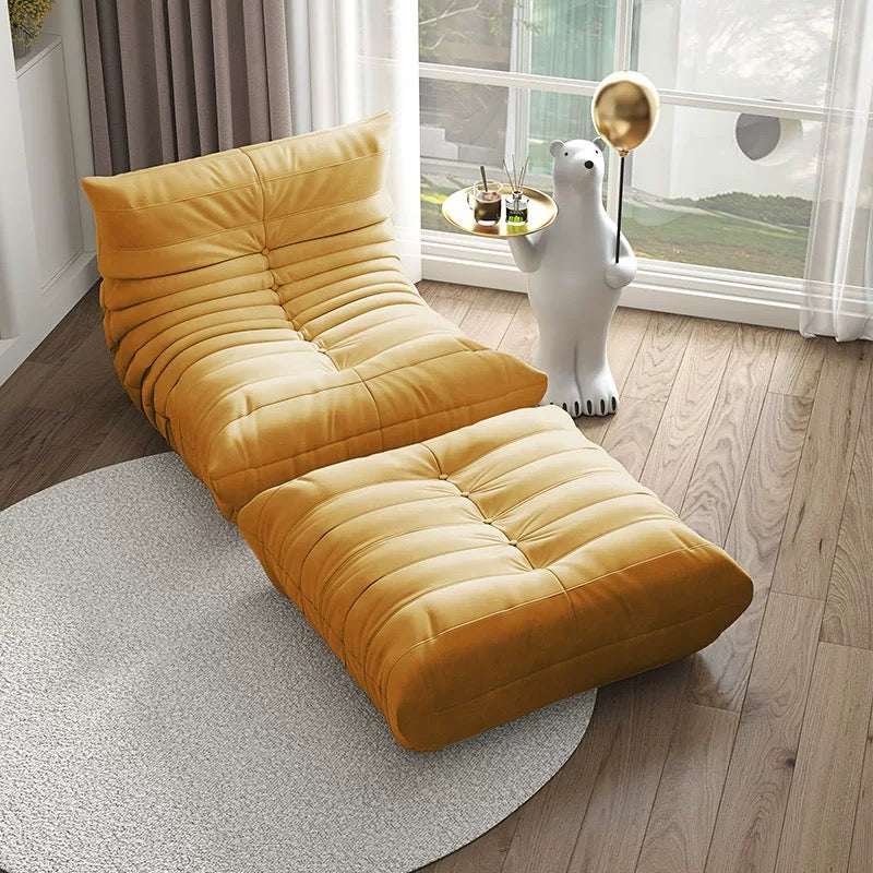 Modern yellow suede armchair and ottoman set with contoured design in bright living room corner