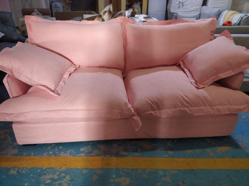 Cloud Sofa in blush pink fabric with a soft, plush finish, featuring loose cushions and broad padded arms.