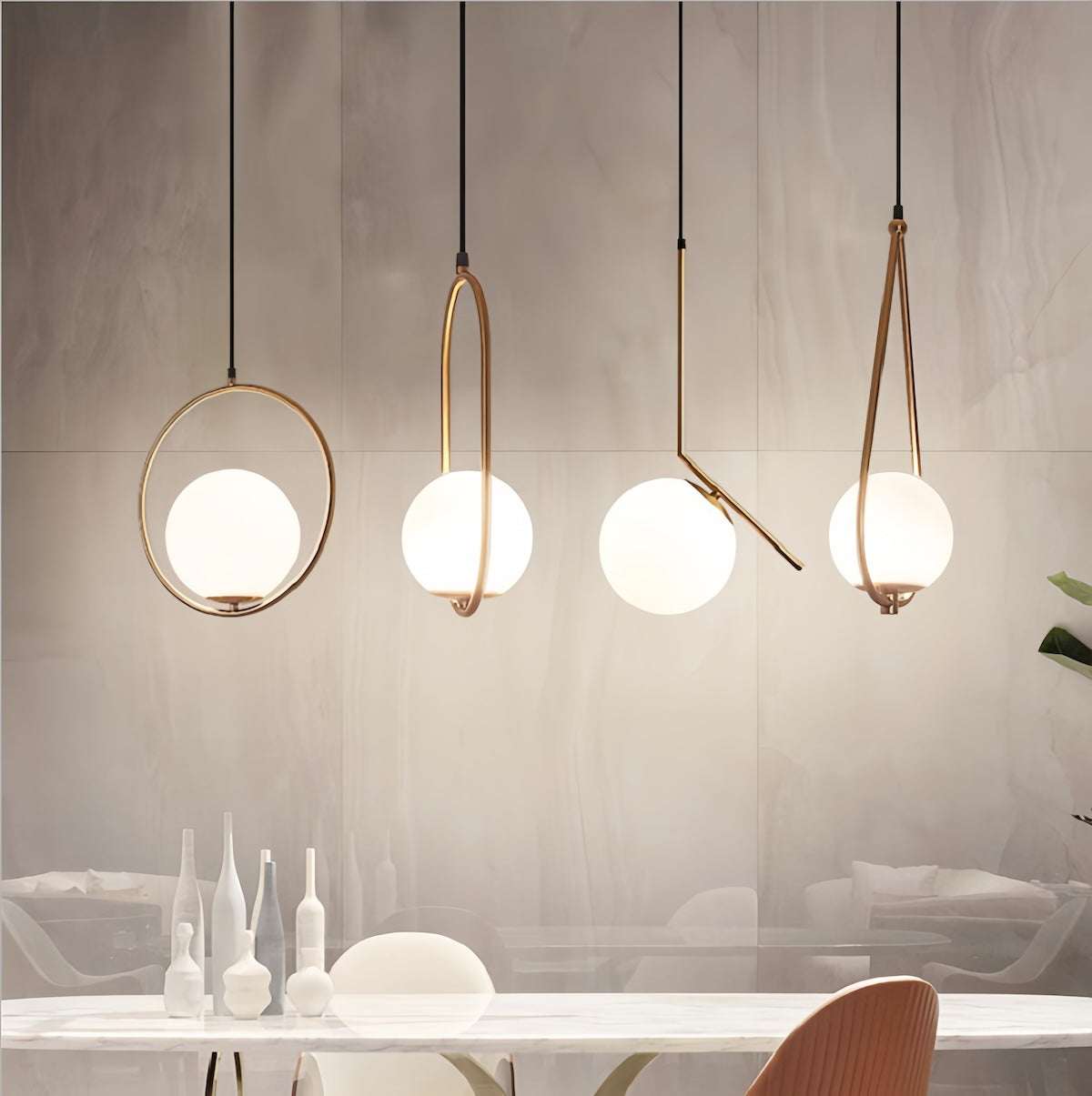 Modern elegant gold pendant light with brushed gold finish and spherical white glass shades hanging above a dining table.