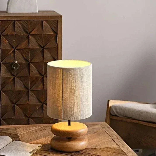 Japanese style wood table lamp with fabric shade on wooden table in cozy room